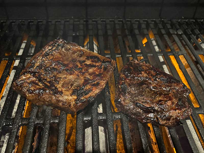 Flap steak cooking on a gas grill