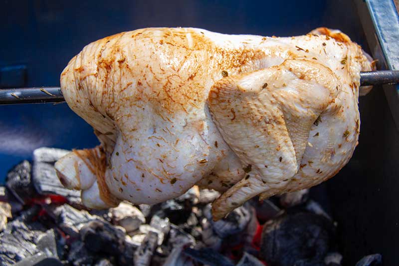 Roasting a whole chicken on a manual rotisserie